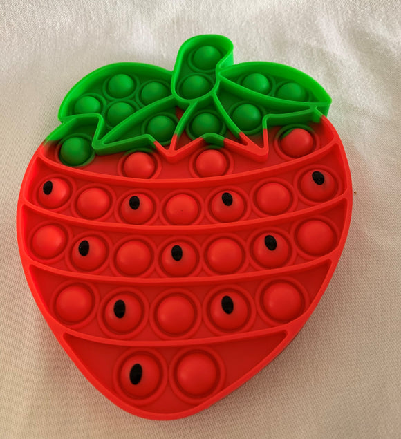 Red and green strawberry popit with black seeds on some of the dimples. Sensory fidget toy.